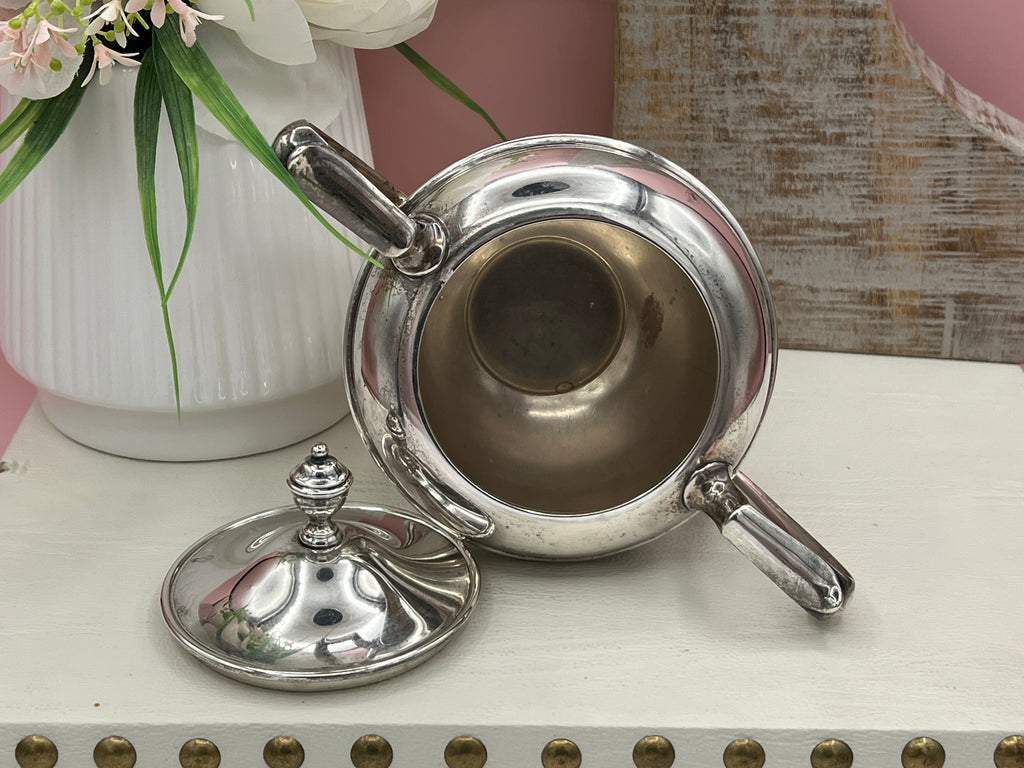 Antique William B. Durgin sterling silver two-handled covered sugar bowl with a polished urn-shaped body, stepped pedestal base, and matching domed lid topped with an urn finial displayed on a white tabletop. - Photo 13