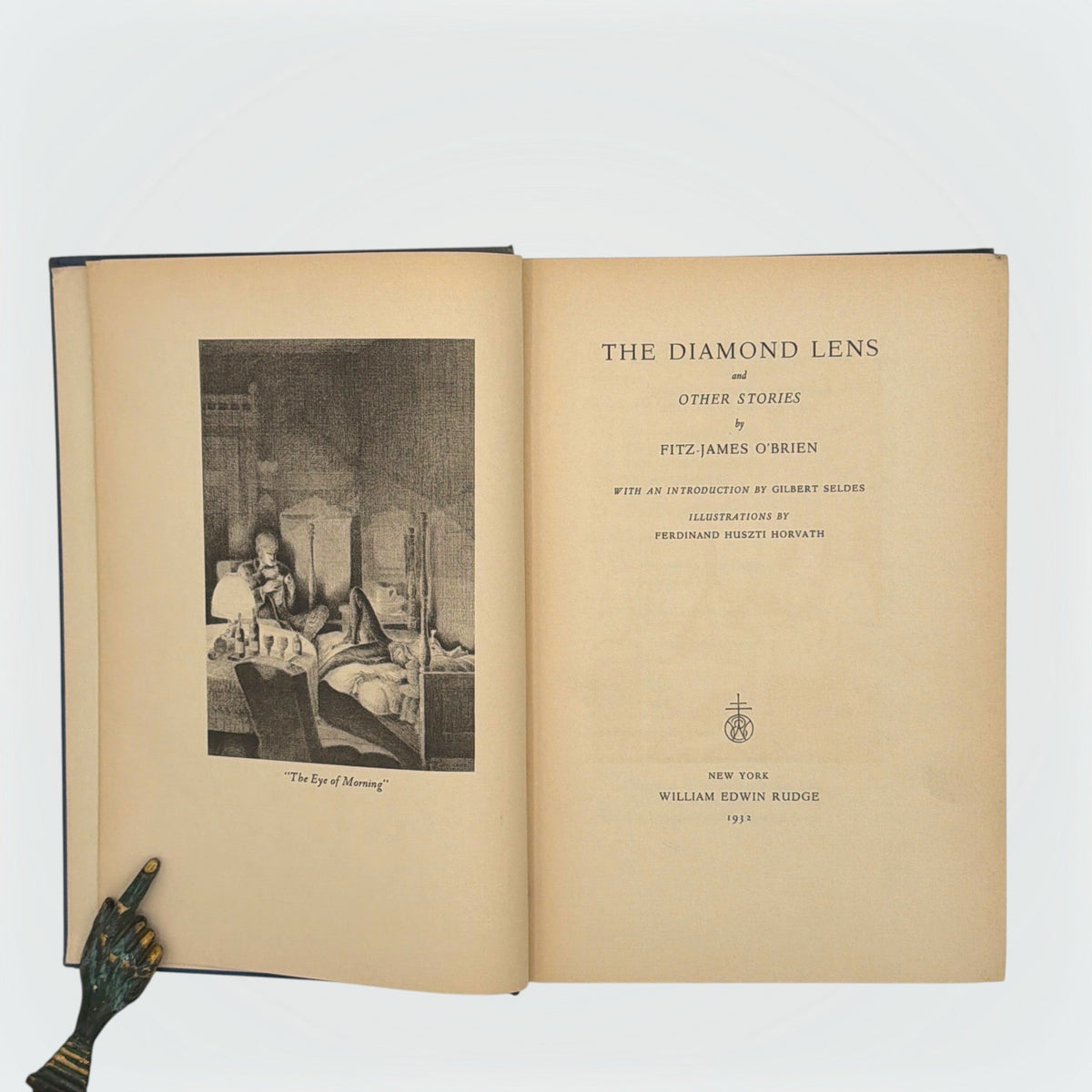Open hardcover volume of The Diamond Lens and Other Stories displaying the printed colophon leaf set in Estienne type on cream paper with dark blue cloth covers. - Photo 3