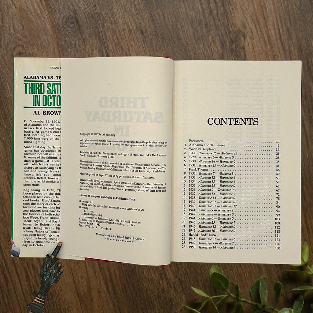 Hardcover book titled Third Saturday in October featuring a green dust jacket with bold white lettering and a full-color action illustration of Alabama and Tennessee football players in mid-tackle. - Photo 5