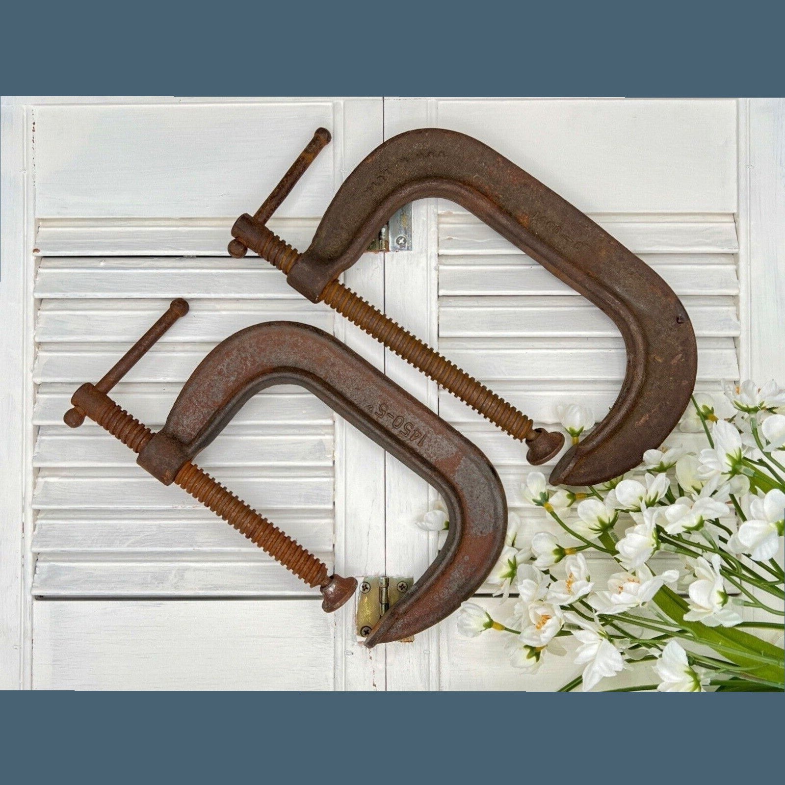 A pair of vintage industrial cast iron C-clamps by the Adjustable Clamp Co. displaying a rich rust brown patina on their heavy frames and steel screws. - Photo 1