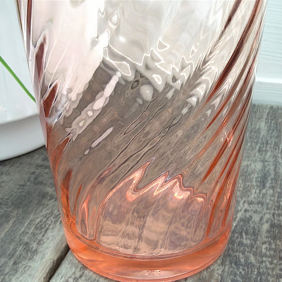 A pair of vintage Arcoroc Rosaline blush pink glass tumblers featuring a diagonal spiral swirl optic texture, displayed side by side on a weathered wooden surface in front of white louvered shutters. - Photo 2