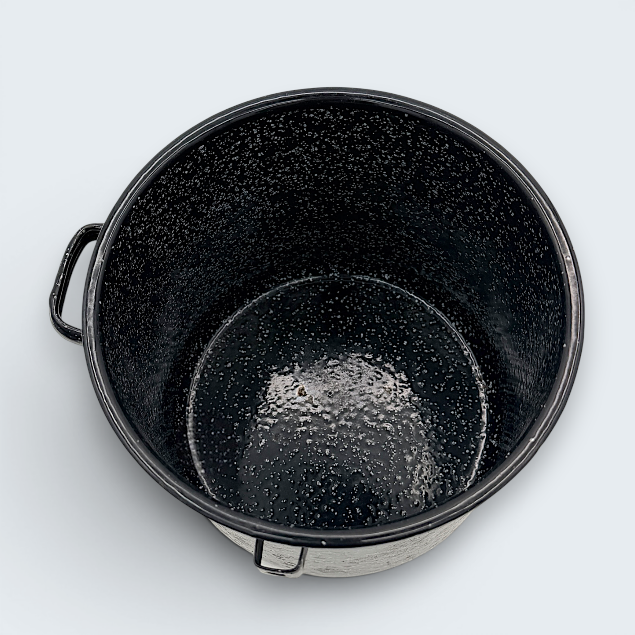 A vintage black speckled enamelware stock pot with a matching lid, featuring a classic white spatter pattern over a glossy black finish and sturdy handles. - Photo 4