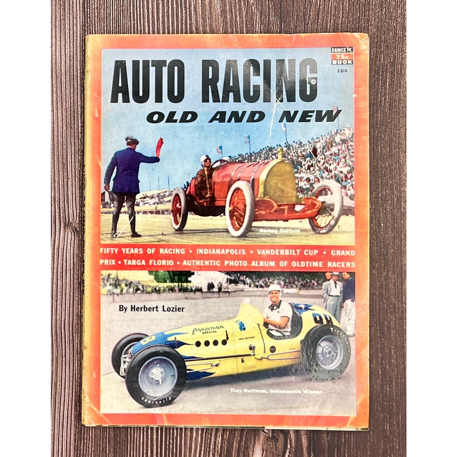 Book cover of 'Auto Racing Old and New' on a wooden surface