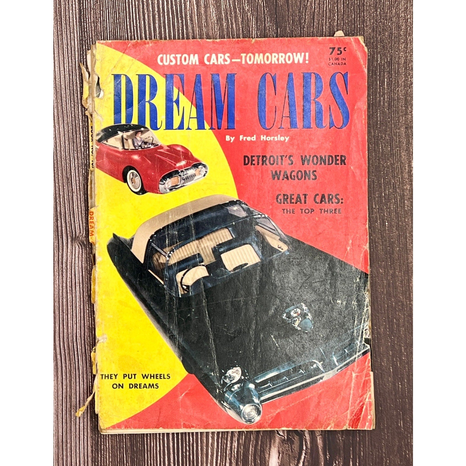 Vintage book cover titled 'Dream Cars' with images of cars on a wooden surface