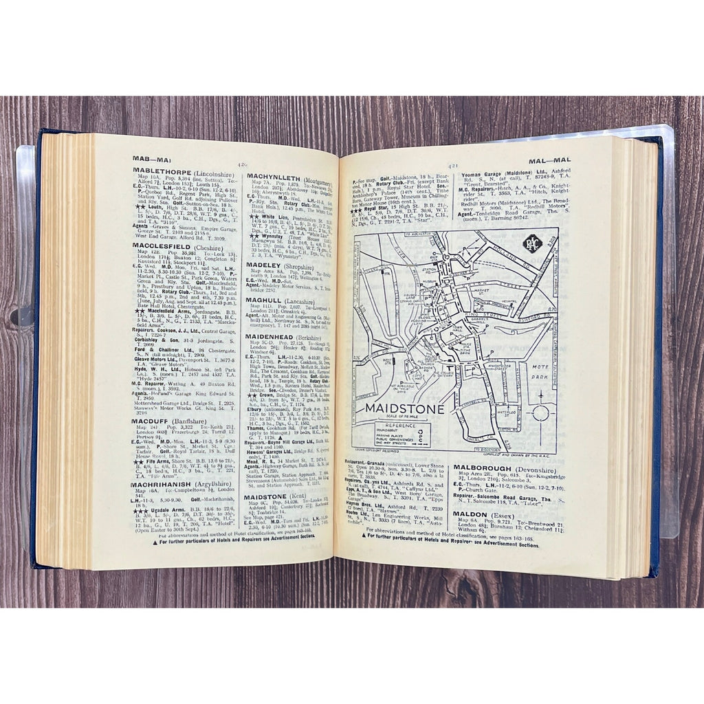Open book with text and a map on a wooden surface
