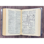 Open book with text and a map on a wooden surface