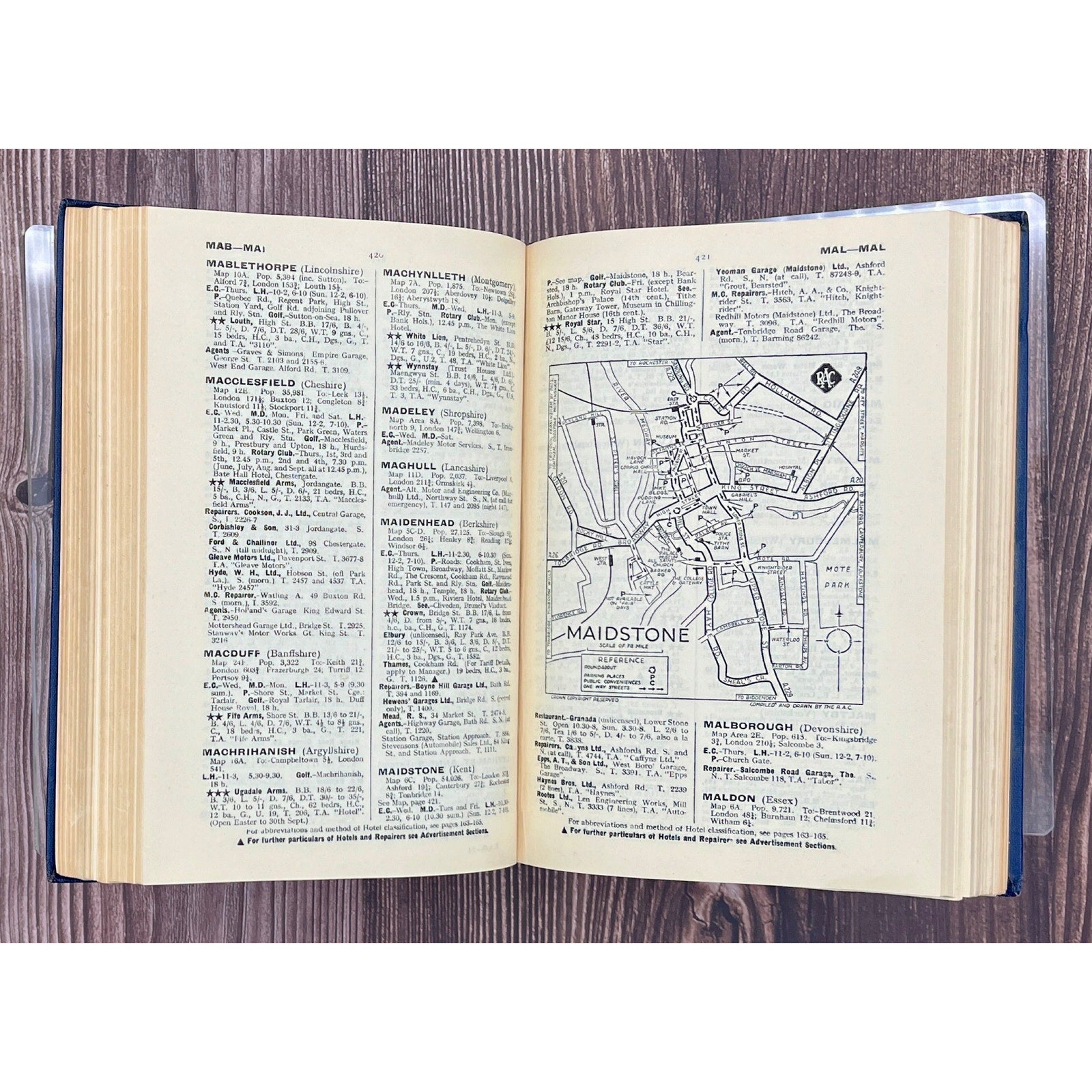 Open book with text and a map on a wooden surface