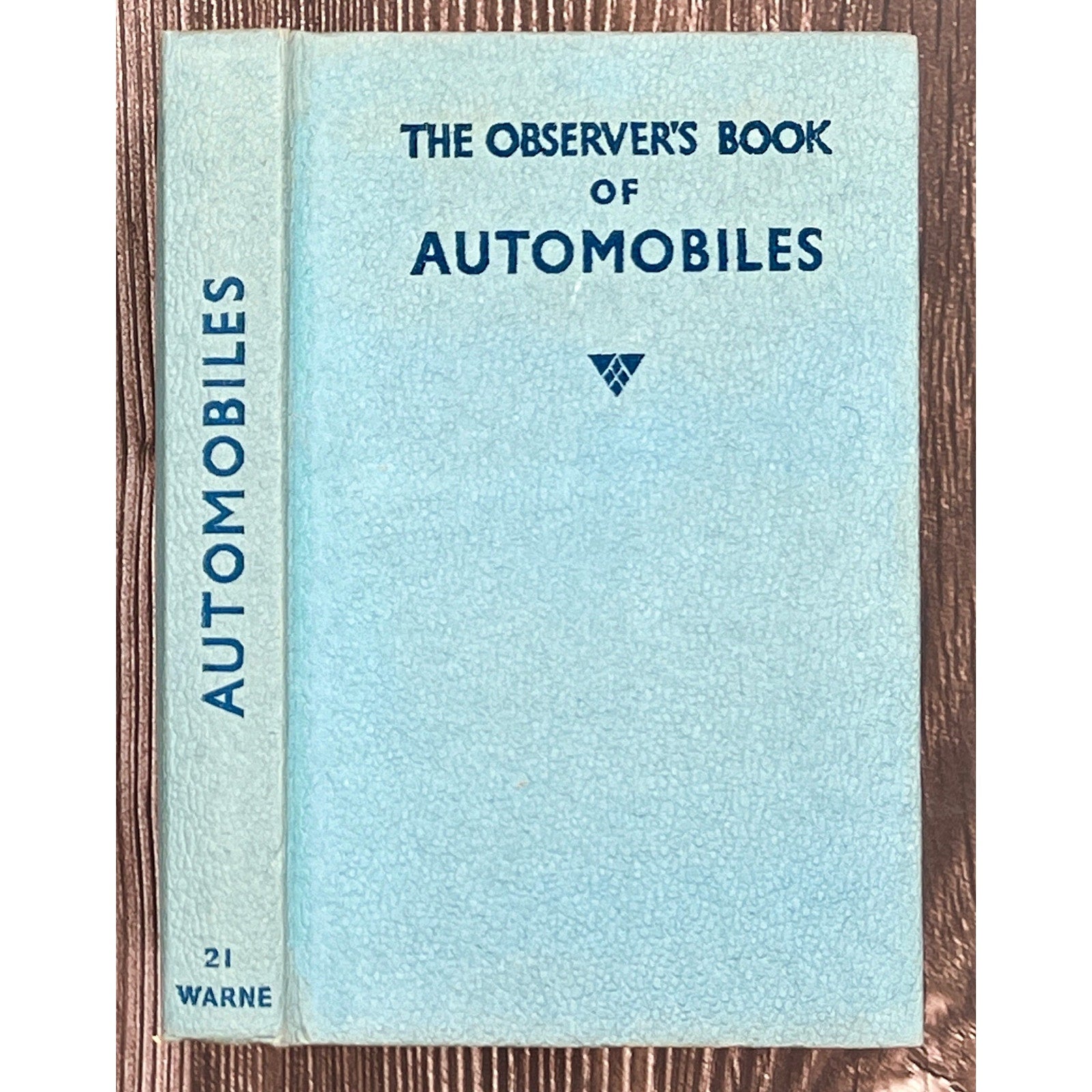 Book titled 'The Observer's Book of Automobiles' on a wooden surface