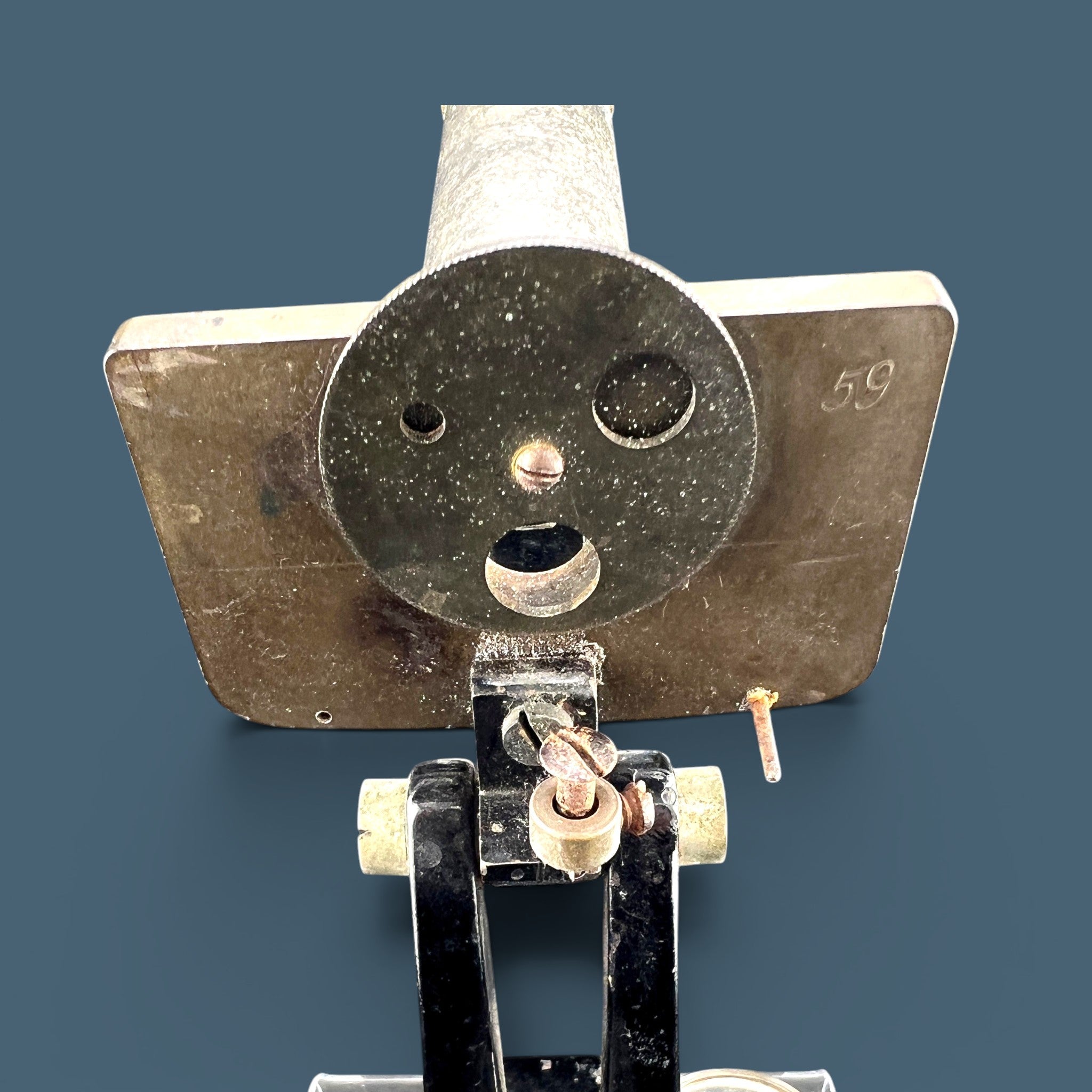 An antique silver-colored steel microscope standing vertically against a solid background, showcasing its classic cylindrical body tube, focus adjustment wheels, and sturdy black metal base. - Photo 4