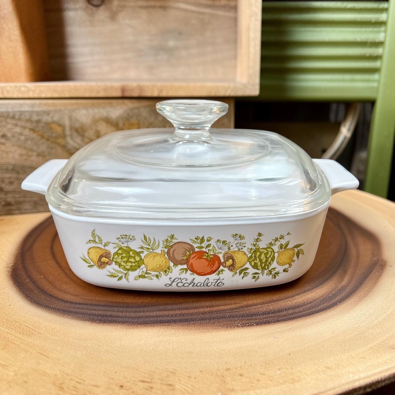A square white Corning Ware casserole dish with a clear Pyrex glass lid, featuring the colorful 1970s Spice O' Life pattern with shallots and herbs printed on the side. - Photo 1