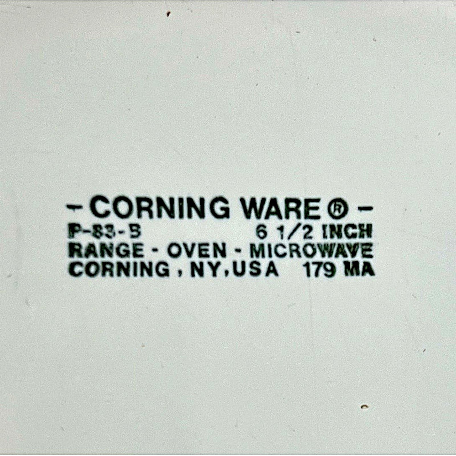 A vintage white Corning Ware P-83-B skillet pan with an integrated handle, resting on a round wooden cutting board. - Photo 4