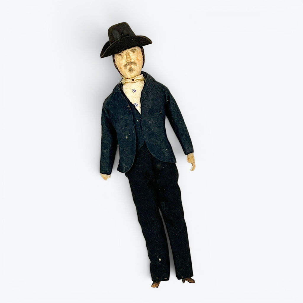 A vintage German miniature bendable dollhouse doll depicting a man in a traditional black suit and wide-brimmed black hat. - Photo 1