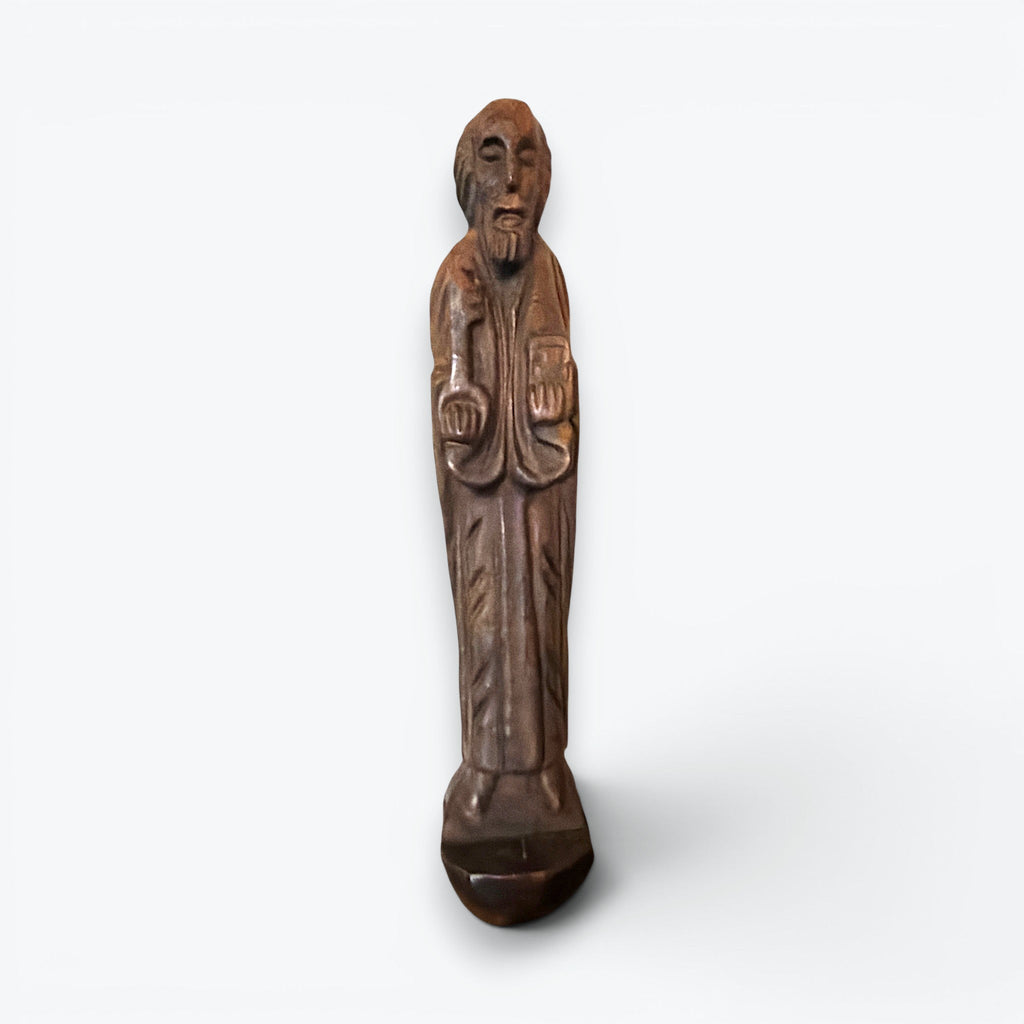 A rustic, hand-carved wooden religious saint figurine standing on a pegged base, featuring intricate carved details of robes, a beard, and symbolic items. - Photo 1
