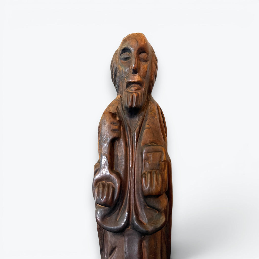 A rustic, hand-carved wooden religious saint figurine standing on a pegged base, featuring intricate carved details of robes, a beard, and symbolic items. - Photo 3