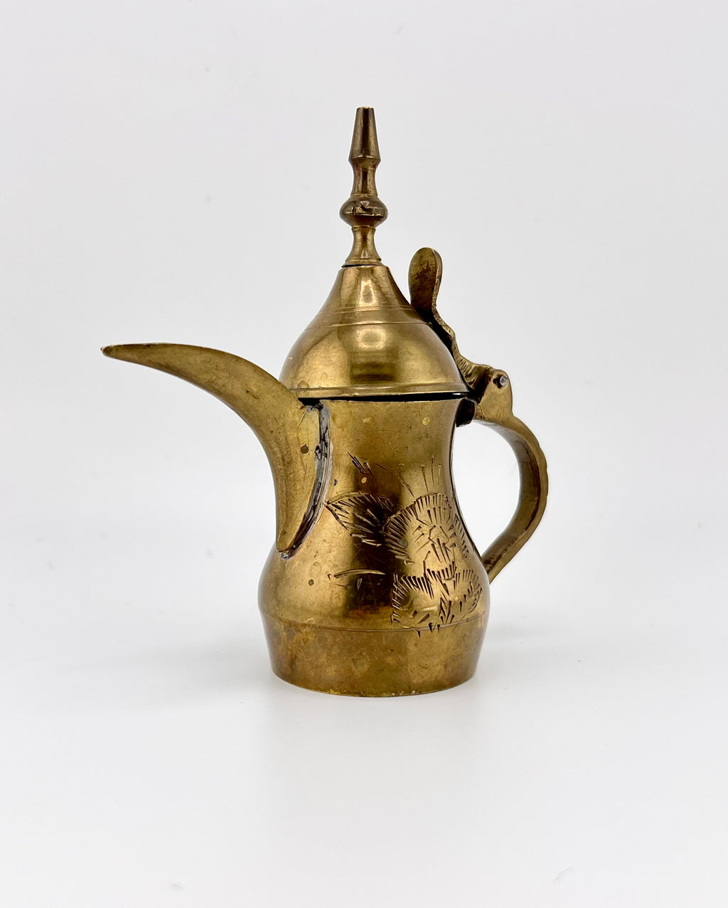 A miniature vintage brass dallah coffee pot featuring hand-chased floral engravings, an elongated curved spout, a rounded body, a side handle, and a hinged conical lid. - Photo 2