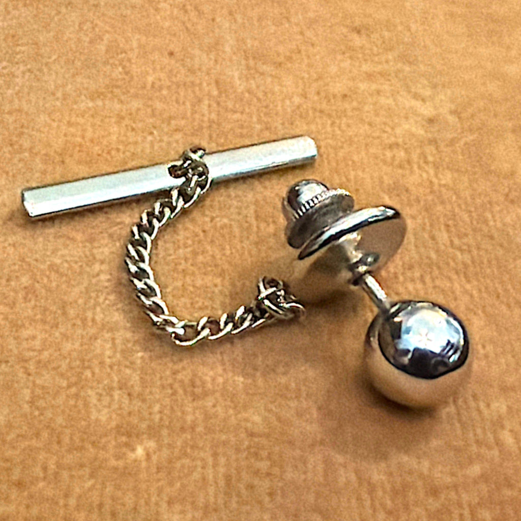 A vintage silver-tone tie tack featuring a polished reflective sphere accent with an attached fine link chain and button bar stay. - Photo 1