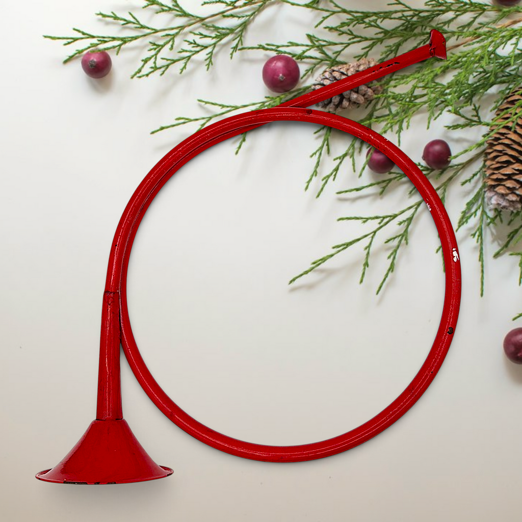 Vintage red painted metal circular hunting horn with flared bell and mouthpiece against a white background - Photo 1