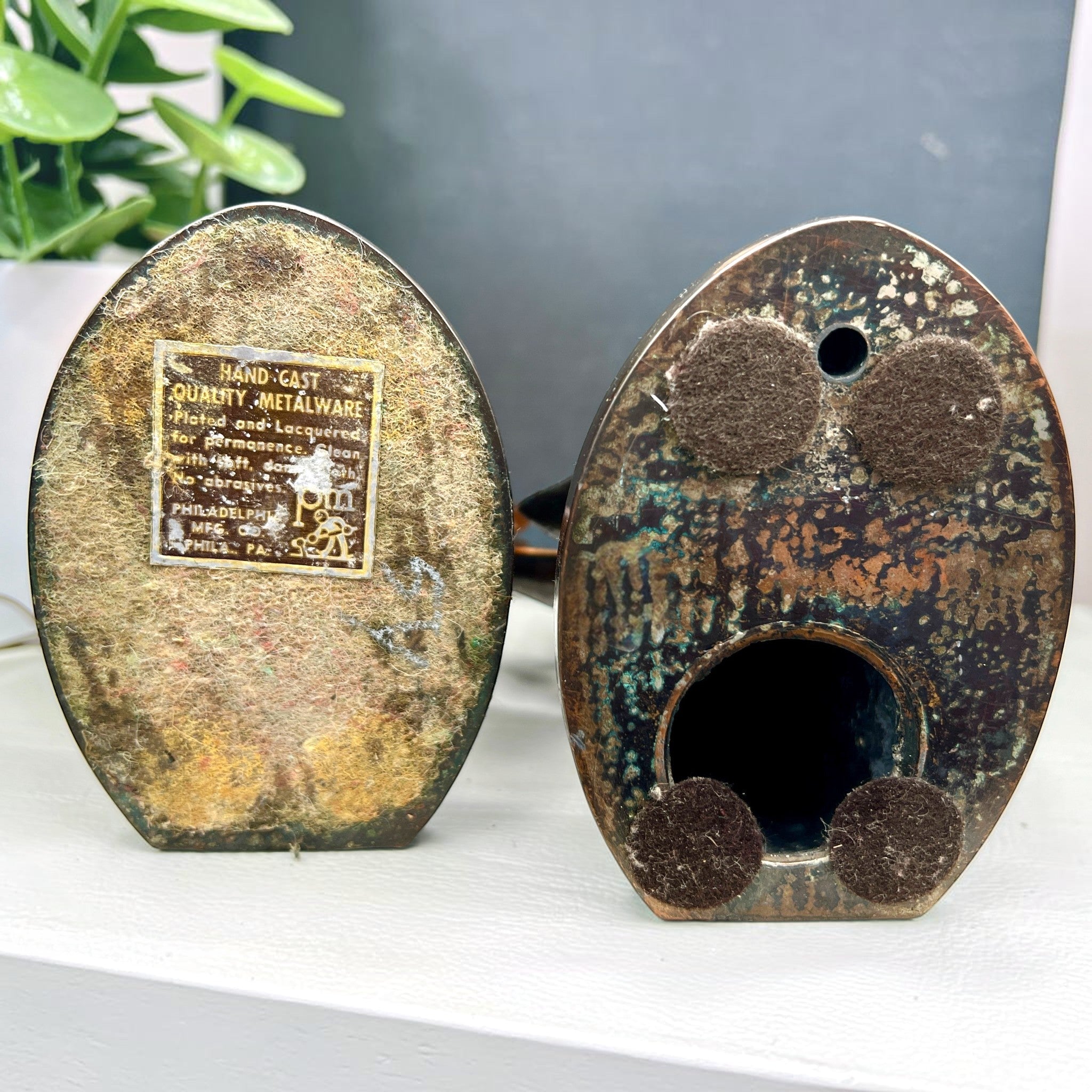 A pair of vintage PMC hand-cast metal oak leaf bookends with a rich bronze finish, designed with stylized lobed leaves and delicate embossed cascading leaf patterns on their curved backs, supporting a dark book on a white surface. - Photo 5