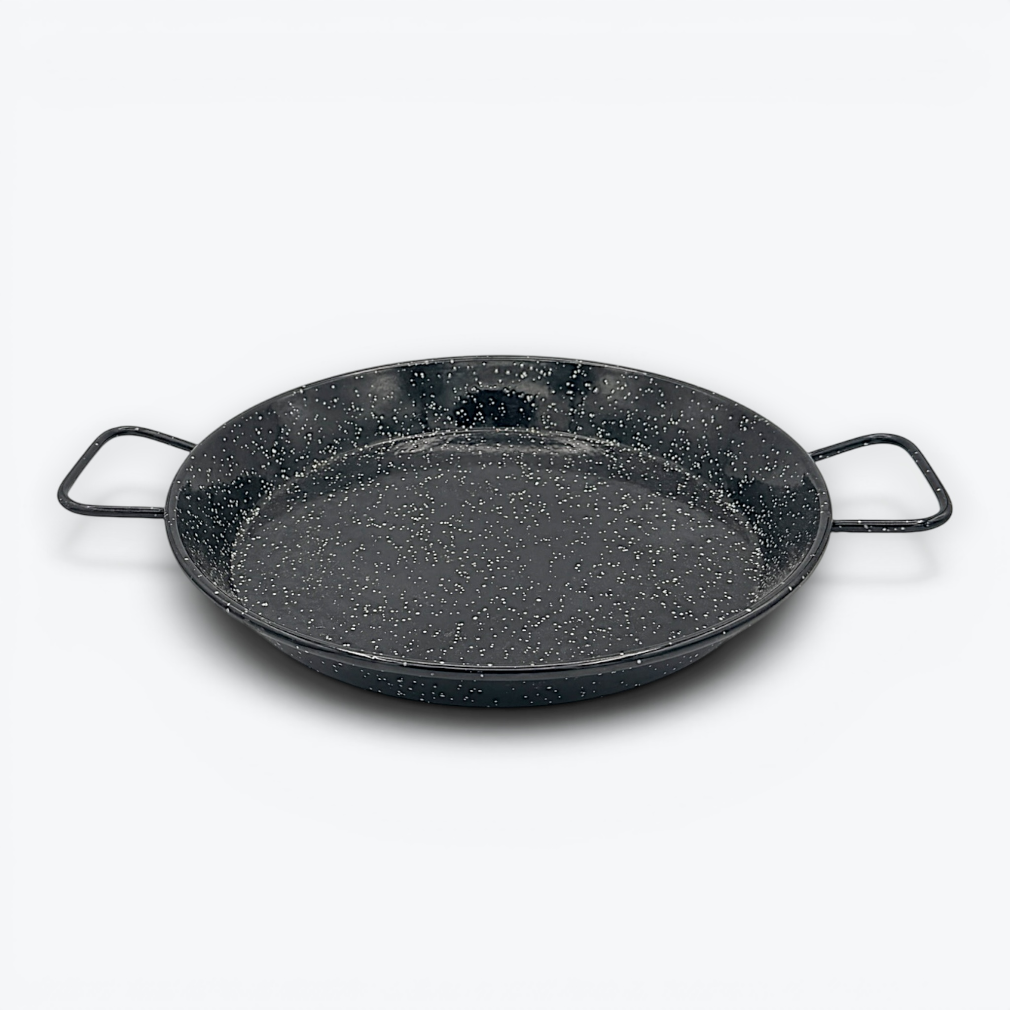 A round, shallow black enamelware paella pan with a white speckled pattern and two wire handles on opposite sides, displayed against a clean white background. - Photo 4