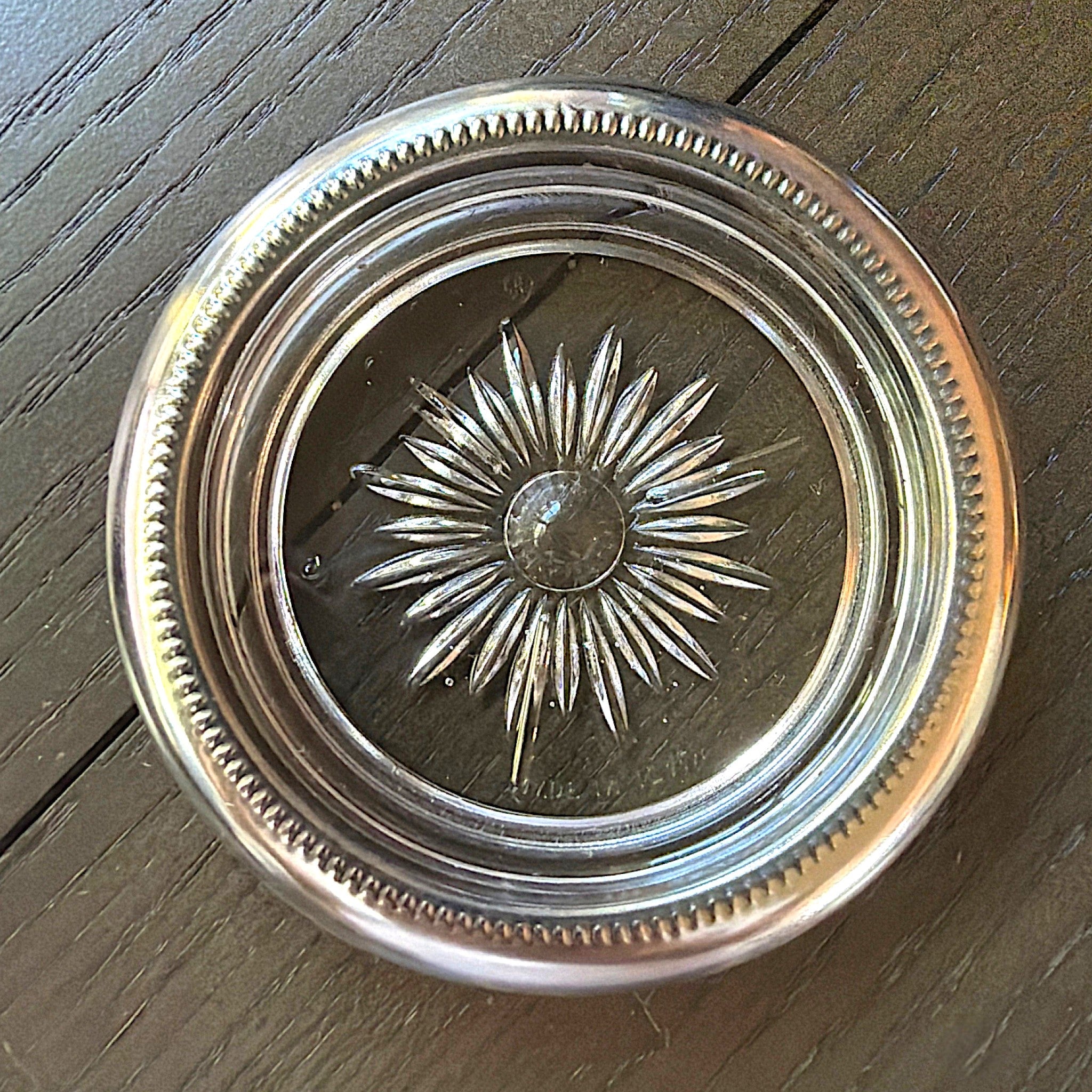 Set of four stacked vintage glass coasters with polished silverplated beaded rims and a clear starburst patterned center. - Photo 1