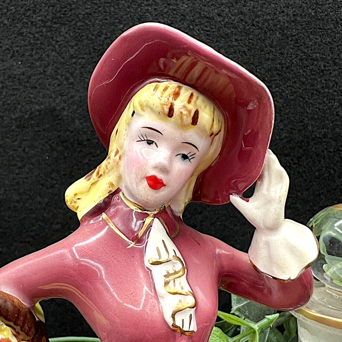 Vintage Ucagco ceramic figurine of an elegant Victorian lady wearing a glossy mauve dress, wide-brimmed bonnet, and white gloves while carrying a flower basket. - Photo 2