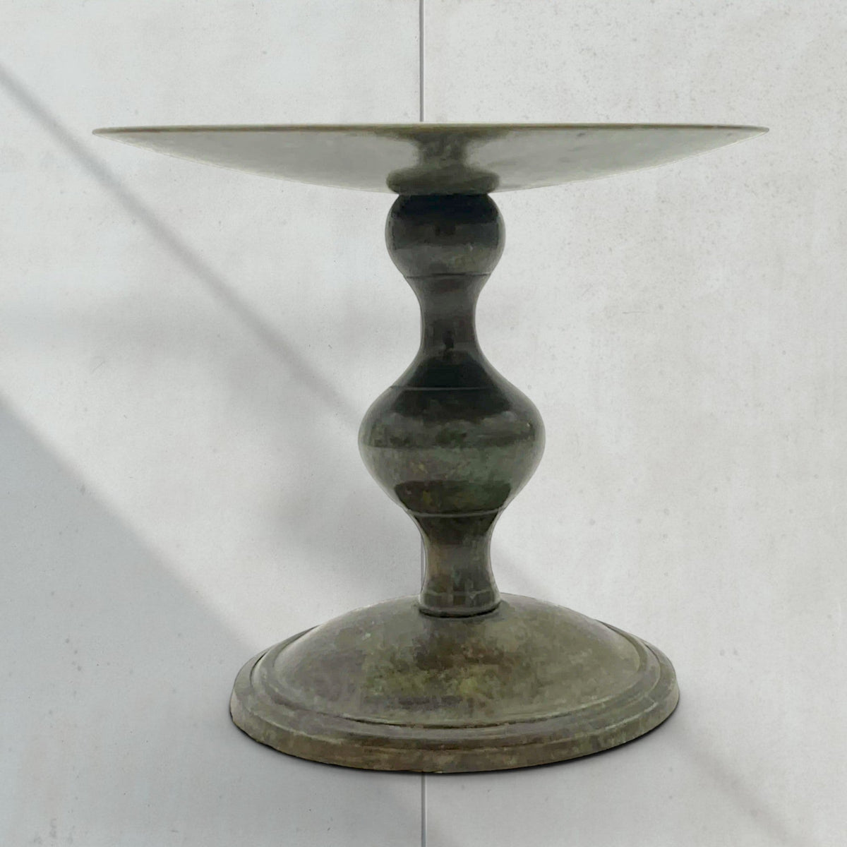 Vintage green verdigris patinated bronze pricket candlestick holder with a wide dished drip pan, central candle spike, and turned baluster stem resting on a circular stepped base. - Photo 2