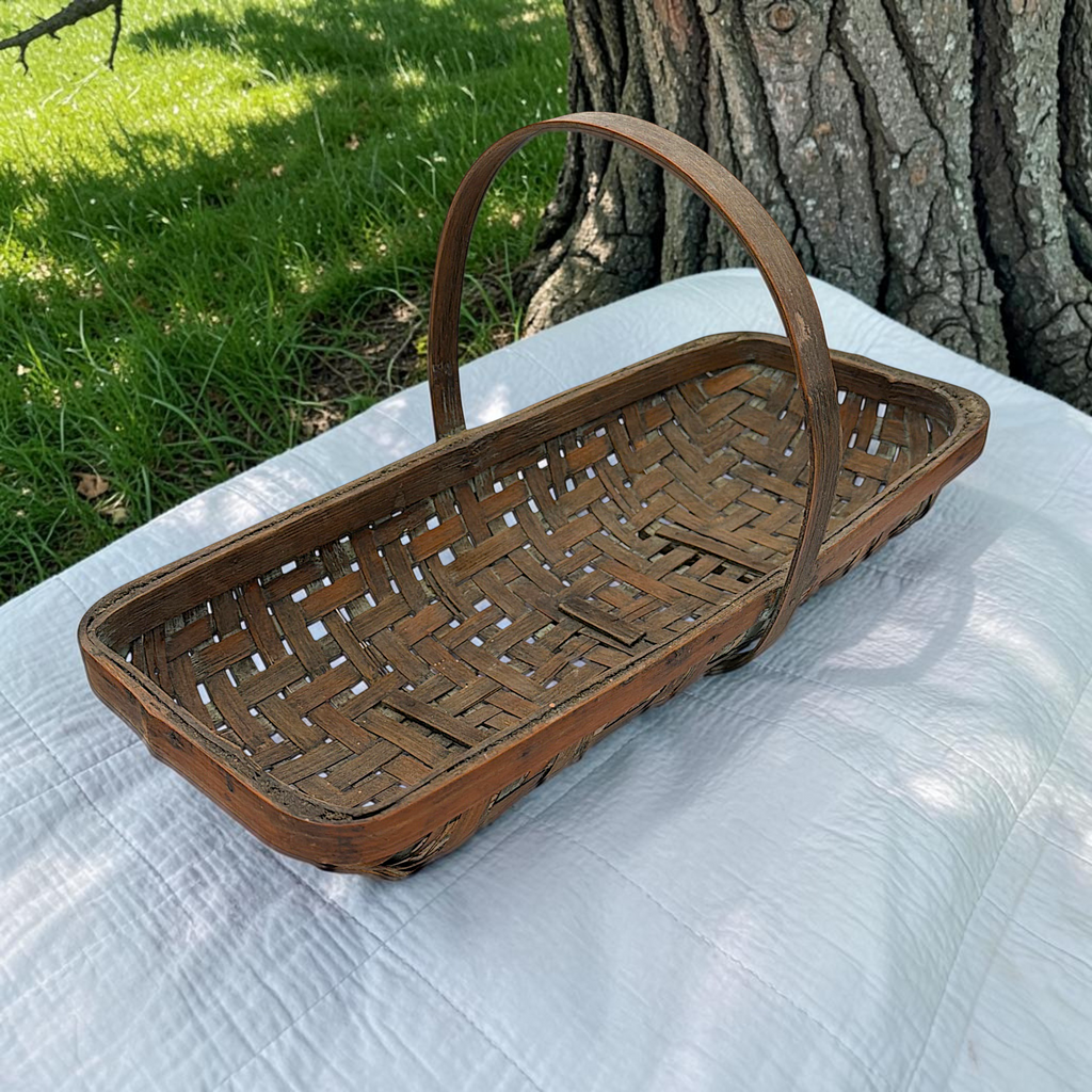 Shallow rectangular vintage wood splint gathering basket with an arched bentwood handle and open weave base resting on a white surface. - Photo 1
