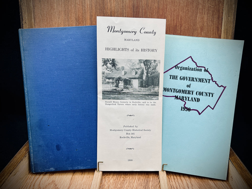 A light blue vintage paper cover of a mid-century Montgomery County Maryland historical publication resting flat on a dark background. - Photo 1
