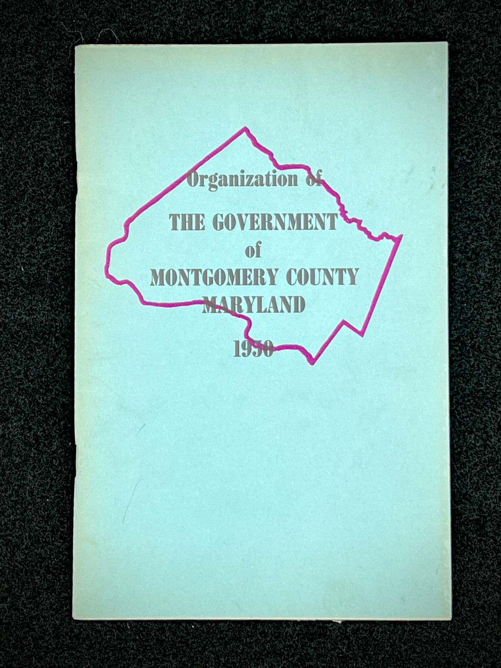 A light blue vintage paper cover of a mid-century Montgomery County Maryland historical publication resting flat on a dark background. - Photo 13